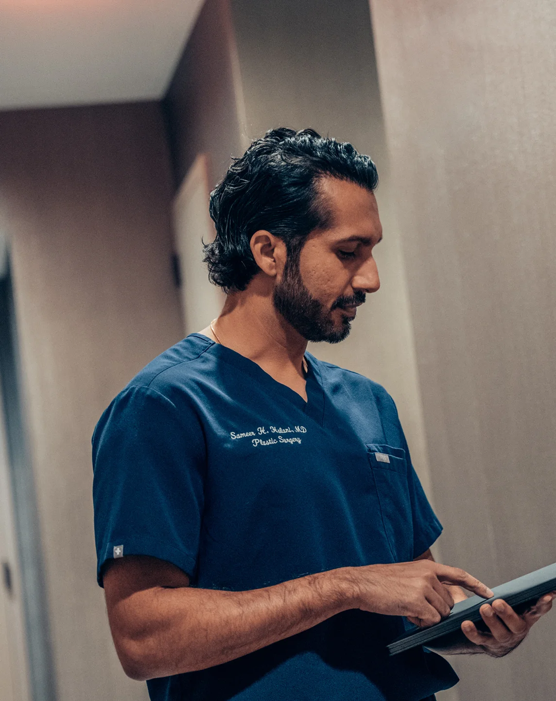 Healthcare professional in blue scrubs using tablet device in medical facility - in New York , NY