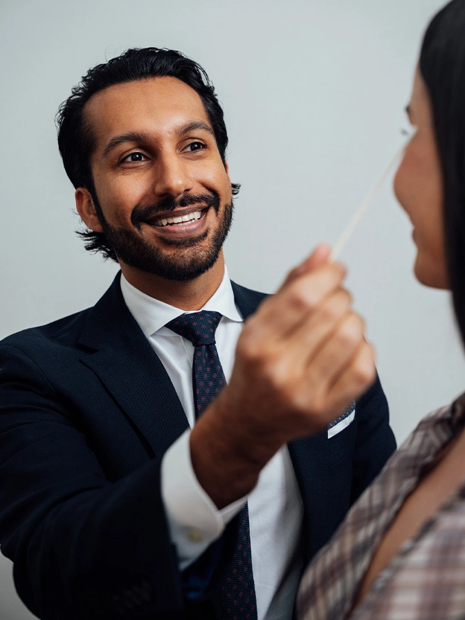 Dr Sameer Halani MD in suit smiling and shaking hands with colleague during business meeting - Upper eyelid lift in New York , NY