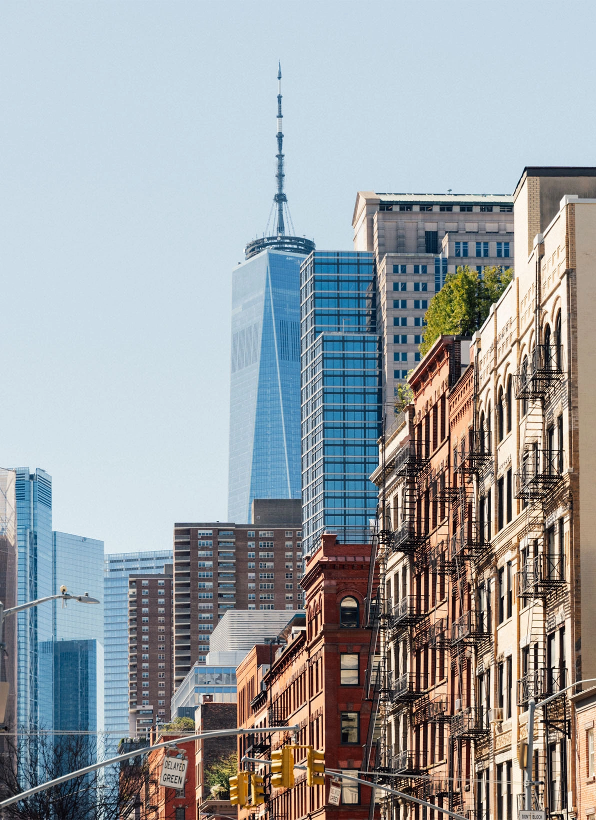 Urban street with brick buildings leading to modern glass skyscrapers in downtown cityscape - in New York , NY